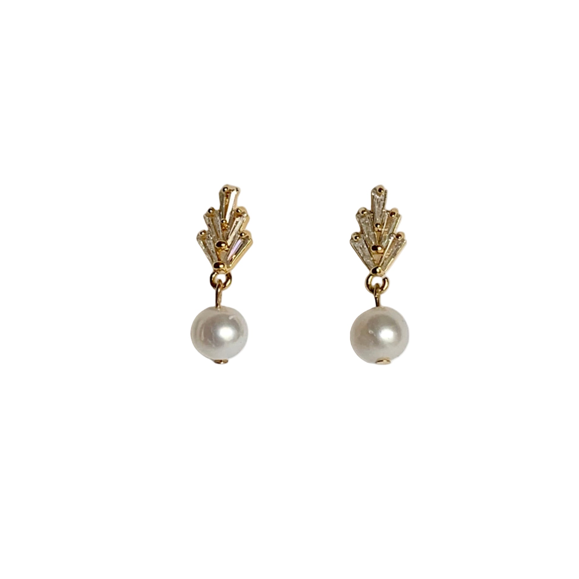 Pair of gold earrings with pearl drops on a light gray background