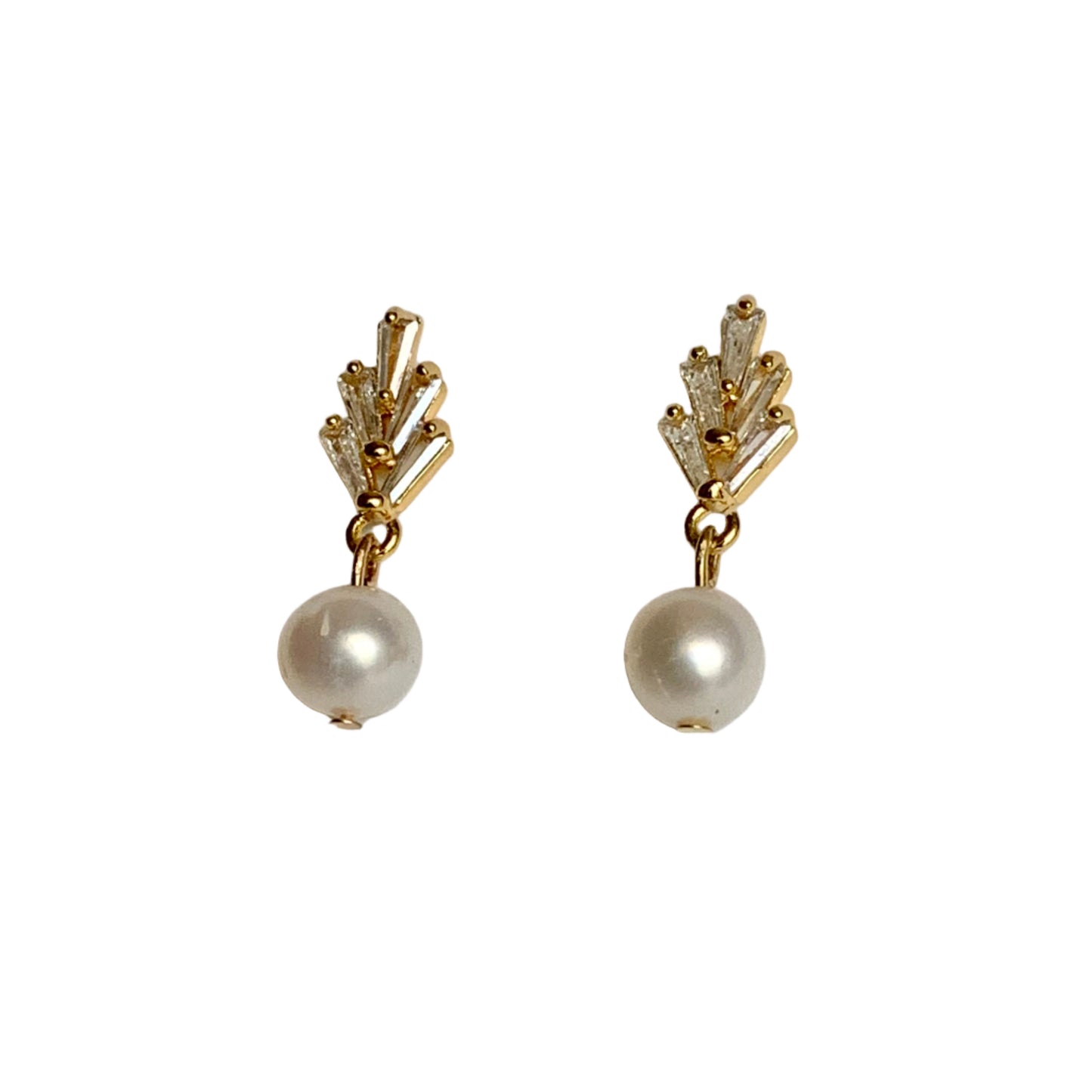 Pair of gold earrings with pearl drops on a light gray background