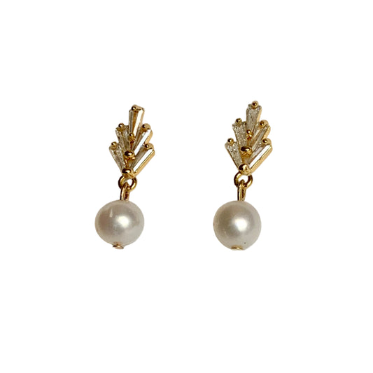 Pair of gold earrings with pearl drops on a light gray background